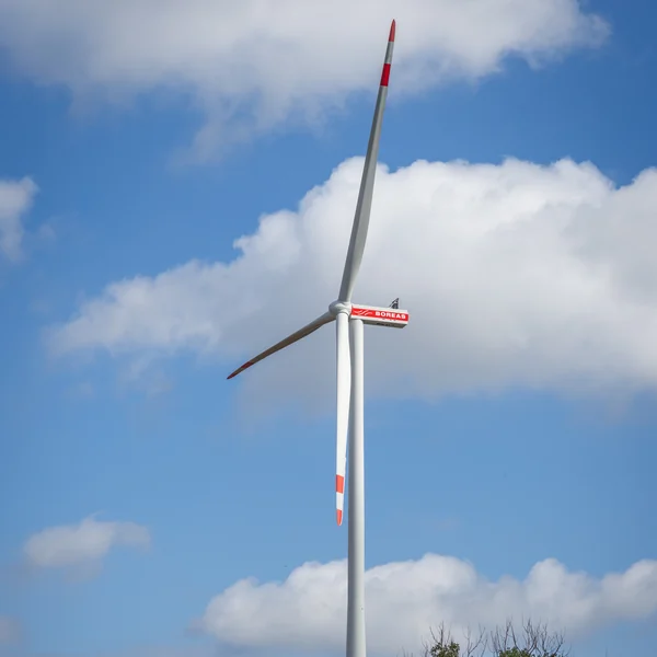 Windrad vor blauem Himmel mit Wolken