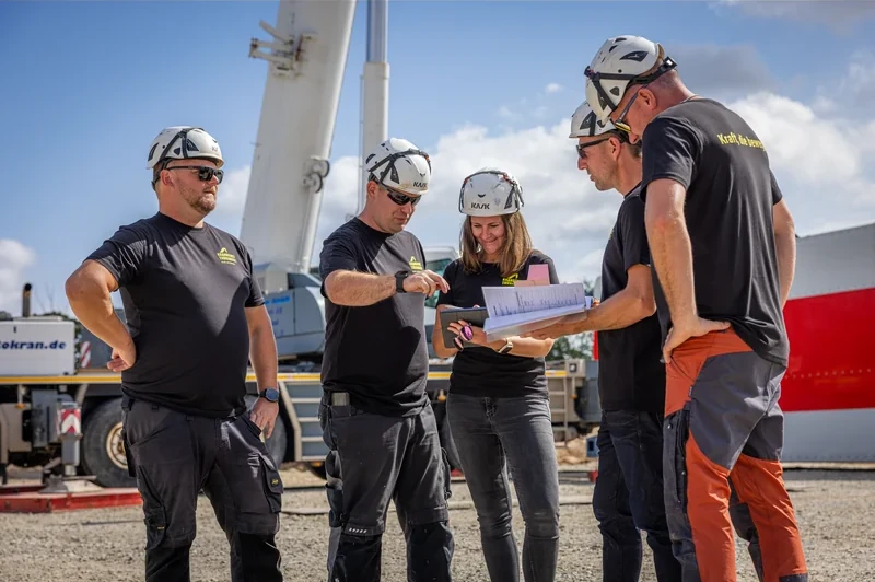 Team von Krandienst Thüringen bespricht einen Plan auf der Baustelle