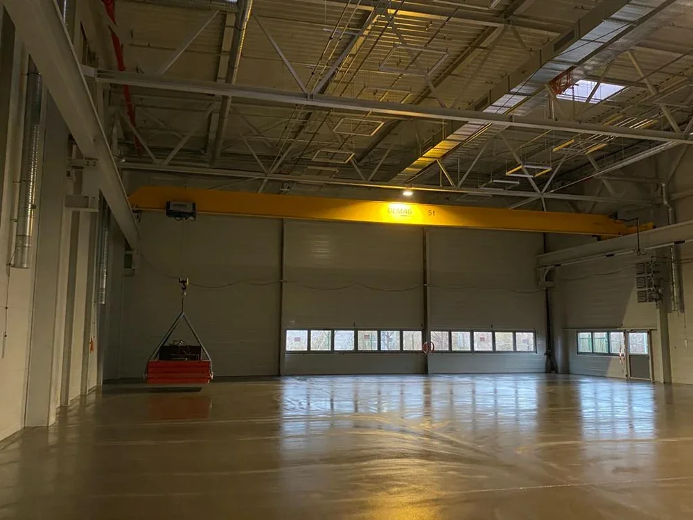 Neue Halle mit gelbem Brückenkran und Prüflast am Haken